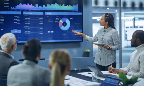 Diverse Modern Office: Successful Black Female Digital Entrepreneur Uses TV Screen with Big Data, Statistics, Talks about Company Growth, Discusses Strategy with Investors, Top Managers, Executives